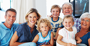 Family Sitting Together With Big Smiles